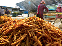 A farmer sorts dried sweet potatoes in Zaozhuang, China, on November 9, 2024. (