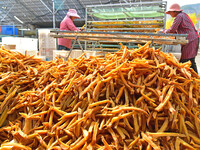 A farmer sorts dried sweet potatoes in Zaozhuang, China, on November 9, 2024. (