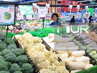 Customers shop for vegetables at a supermarket in Nanjing, China, on November 9, 2024. (