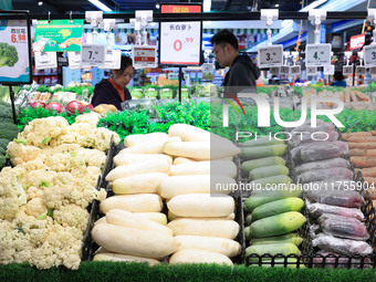 Customers shop for vegetables at a supermarket in Nanjing, China, on November 9, 2024. (