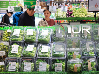 Customers shop for vegetables at a supermarket in Nanjing, China, on November 9, 2024. (