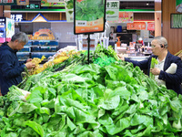 Customers shop for vegetables at a supermarket in Nanjing, China, on November 9, 2024. (