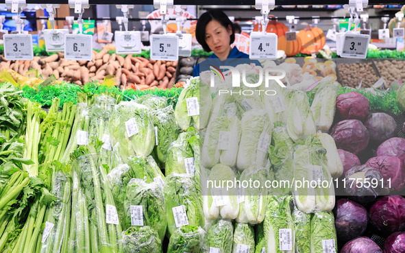 Customers shop for vegetables at a supermarket in Nanjing, China, on November 9, 2024. 