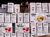 A trader speaks on his phone as boxes of apples are kept for sale at Asia's second largest fruit market in Sopore, Jammu and Kashmir, India,...