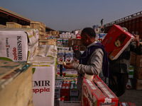 A trader drinks tea as laborers load apple boxes onto trucks, which are sent to different parts of the country from Asia's second-largest fr...