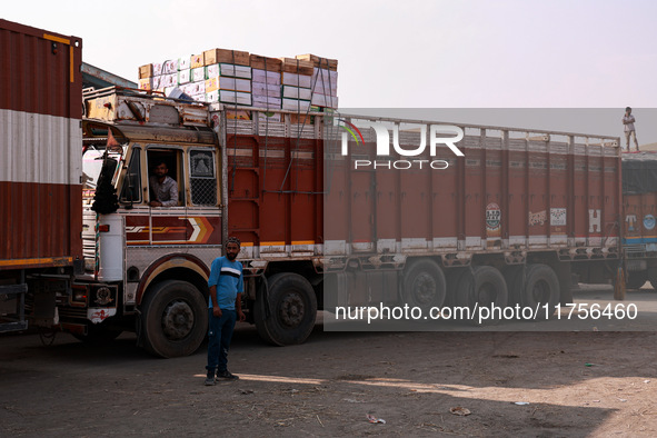 Trucks loaded with apple boxes leave from Asia's second-largest fruit market to different parts of the country in Sopore, Jammu and Kashmir,...