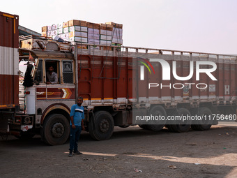 Trucks loaded with apple boxes leave from Asia's second-largest fruit market to different parts of the country in Sopore, Jammu and Kashmir,...