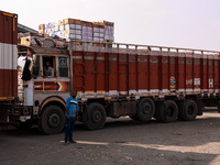 Trucks loaded with apple boxes leave from Asia's second-largest fruit market to different parts of the country in Sopore, Jammu and Kashmir,...