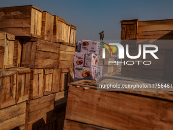 Wooden boxes filled with fresh apples are kept at Asia's second-largest fruit market for sale in Sopore, Jammu and Kashmir, India, on Novemb...