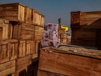 Wooden boxes filled with fresh apples are kept at Asia's second-largest fruit market for sale in Sopore, Jammu and Kashmir, India, on Novemb...