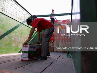 Labourers load apple boxes onto trucks, which are sent to different parts of the country from Asia's second-largest fruit mandi in Sopore, J...