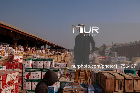 Labourers load apple boxes onto trucks, which are sent to different parts of the country from Asia's second-largest fruit mandi in Sopore, J...