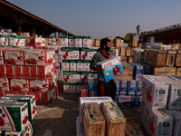 Labourers load apple boxes onto trucks, which are sent to different parts of the country from Asia's second-largest fruit mandi in Sopore, J...