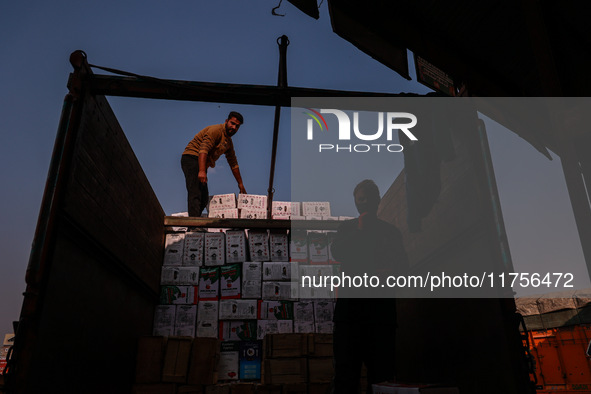 Labourers load apple boxes onto trucks, which are sent to different parts of the country from Asia's second-largest fruit mandi in Sopore, J...