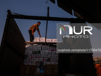 Labourers load apple boxes onto trucks, which are sent to different parts of the country from Asia's second-largest fruit mandi in Sopore, J...