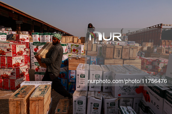 Labourers load apple boxes onto trucks, which are sent to different parts of the country from Asia's second-largest fruit mandi in Sopore, J...