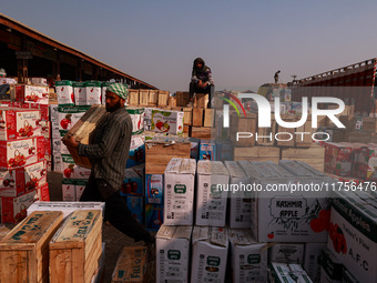 Labourers load apple boxes onto trucks, which are sent to different parts of the country from Asia's second-largest fruit mandi in Sopore, J...