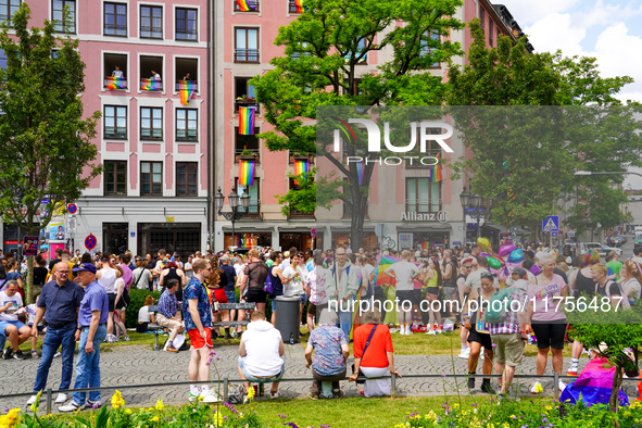 The Gartnerplatz square in Munich, Germany, on June 22, 2024, is filled with vibrant rainbow flags draped across the buildings, and many par...