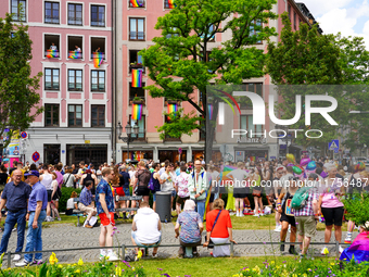 The Gartnerplatz square in Munich, Germany, on June 22, 2024, is filled with vibrant rainbow flags draped across the buildings, and many par...