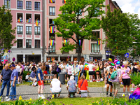 The Gartnerplatz square in Munich, Germany, on June 22, 2024, is filled with vibrant rainbow flags draped across the buildings, and many par...