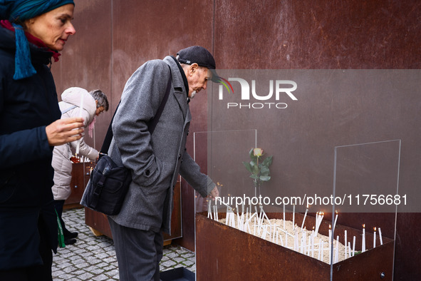 People light candles at Berlin Wall Memorial after the commemoration ceremony marking the 35th anniversary of the fall of the Berlin Wall. B...