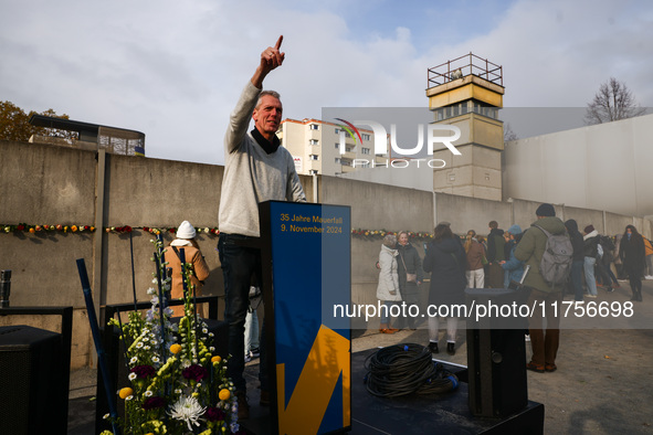 A man poses for a picture at Berlin Wall Memorial after the commemoration ceremony marking the 35th anniversary of the fall of the Berlin Wa...