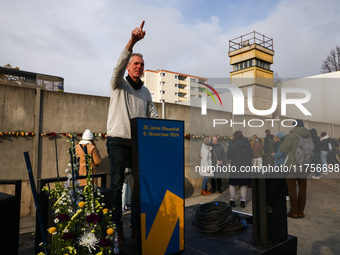 A man poses for a picture at Berlin Wall Memorial after the commemoration ceremony marking the 35th anniversary of the fall of the Berlin Wa...