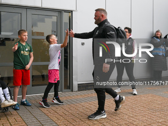 Wayne Rooney, manager of Plymouth Argyle, gives a high-five to a supporter during the Sky Bet Championship match between Derby County and Pl...