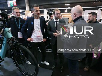 France's Minister for the Economy, Finance and Industry, Antoine Armand, speaks with personnel at a stand showcasing an Ymagine electric bic...