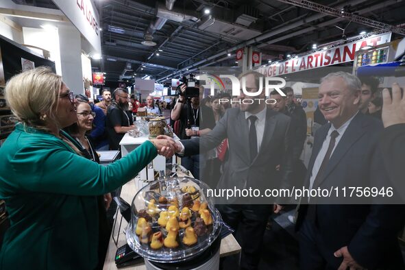 France's Minister for the Economy, Finance and Industry, Antoine Armand, samples pastries at the ''Les Petits Bouchon'' brand's stand as he...