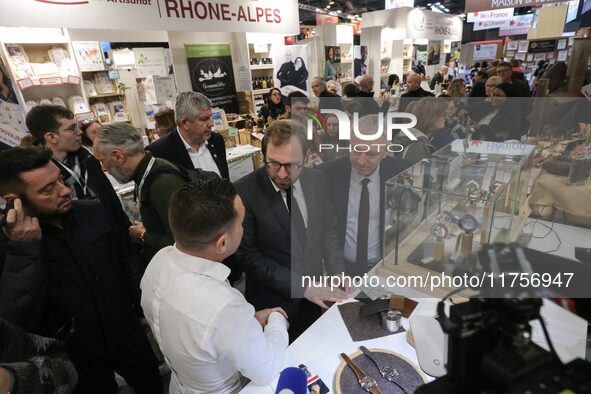 France's Minister for the Economy, Finance and Industry, Antoine Armand (center), examines watches made by the French watch manufacturing br...