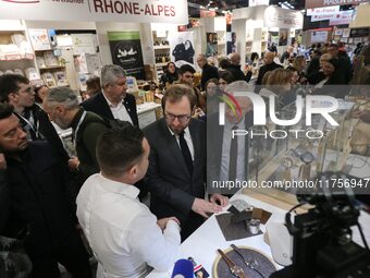 France's Minister for the Economy, Finance and Industry, Antoine Armand (center), examines watches made by the French watch manufacturing br...