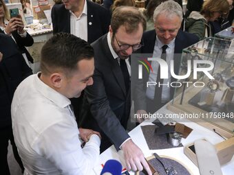 France's Minister for the Economy, Finance and Industry, Antoine Armand (center), examines watches made by the French watch manufacturing br...