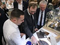 France's Minister for the Economy, Finance and Industry, Antoine Armand (center), examines watches made by the French watch manufacturing br...