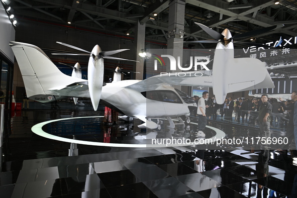 Visitors visit the vertaxi booth in the ''Future Low Altitude Travel'' area of the Automobile Pavilion at the 7th China International Import...