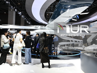 Visitors visit the vertaxi booth in the ''Future Low Altitude Travel'' area of the Automobile Pavilion at the 7th China International Import...