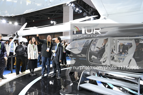 Visitors visit the vertaxi booth in the ''Future Low Altitude Travel'' area of the Automobile Pavilion at the 7th China International Import...