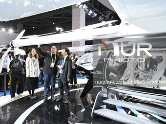 Visitors visit the vertaxi booth in the ''Future Low Altitude Travel'' area of the Automobile Pavilion at the 7th China International Import...