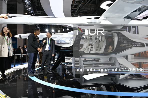 Visitors visit the vertaxi booth in the ''Future Low Altitude Travel'' area of the Automobile Pavilion at the 7th China International Import...