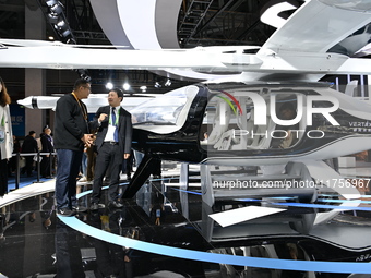 Visitors visit the vertaxi booth in the ''Future Low Altitude Travel'' area of the Automobile Pavilion at the 7th China International Import...