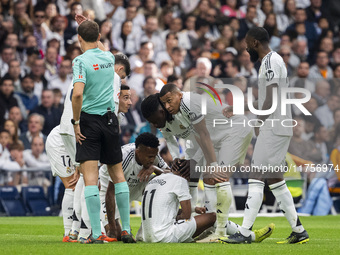 Rodrygo Silva de Goes of Real Madrid CF (C) is injured on the ground surrounded by his teammates (from L to R) Lucas Vazquez, Eder Militao,...