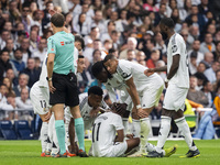 Rodrygo Silva de Goes of Real Madrid CF (C) is injured on the ground surrounded by his teammates (from L to R) Lucas Vazquez, Eder Militao,...