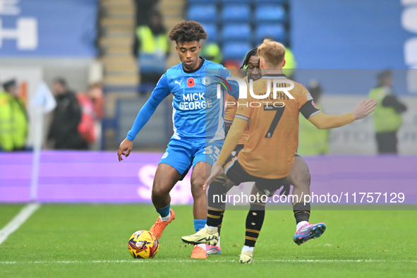 James Donnelly (33 Peterborough United) is challenged by James Brophy (7 Cambridge United) during the Sky Bet League 1 match between Peterbo...