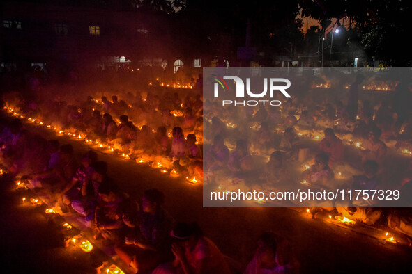 Devotees offer prayers by lighting oil lamps and incense sticks to Sri Loknath Brahmachari on the occasion of Karthik Brata at a Loknath Bra...