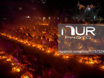 Devotees offer prayers by lighting oil lamps and incense sticks to Sri Loknath Brahmachari on the occasion of Karthik Brata at a Loknath Bra...