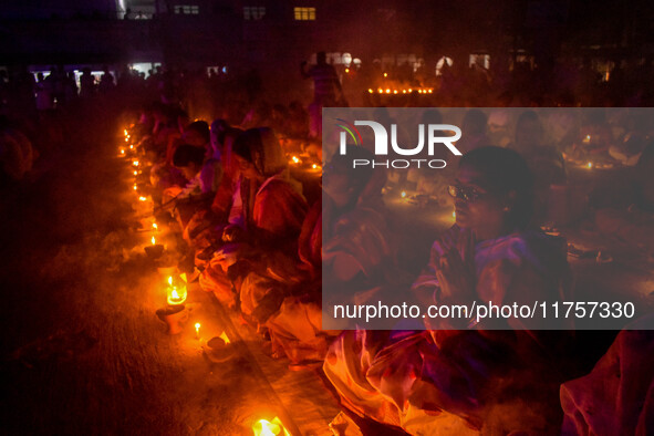 Devotees offer prayers by lighting oil lamps and incense sticks to Sri Loknath Brahmachari on the occasion of Karthik Brata at a Loknath Bra...