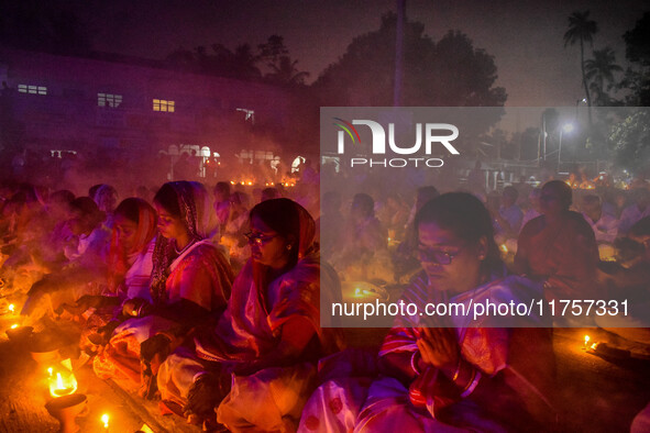 Devotees offer prayers by lighting oil lamps and incense sticks to Sri Loknath Brahmachari on the occasion of Karthik Brata at a Loknath Bra...