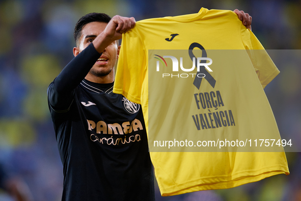 Ilias Akhomach of Villarreal CF celebrates after scoring the team's first goal and shows a t-shirt supporting the victims of the Valencia fl...