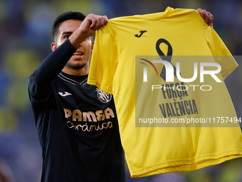 Ilias Akhomach of Villarreal CF celebrates after scoring the team's first goal and shows a t-shirt supporting the victims of the Valencia fl...