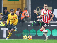 #22, Nelson Semedo of Wolves and #35, Jan Bednarek of Southampton chase after the ball during the Premier League match between Wolverhampton...